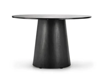 Modernus apvalus stalas su tamsiu, elegantišku paviršiumi ir platėjančiu pagrindu.