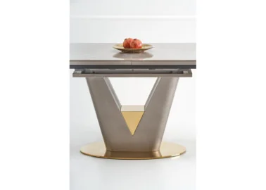 Valentino stalas yra modernus ir prabangus, su V formos metaliniu rėmu, papuoštu auksiniais akcentais. Jis turi šviesų akmens ar marmuro stalviršį, suteikiantį natūralumo ir elegancijos. Apvalus auksinis pagrindas prideda stabilumo ir išskirtinumo, todėl stalas puikiai tinka šiuolaikiškam interjerui.