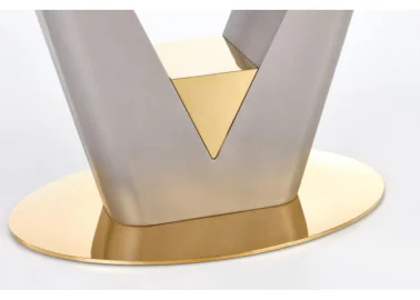Valentino stalas yra modernus ir prabangus, su V formos metaliniu rėmu, papuoštu auksiniais akcentais. Jis turi šviesų akmens ar marmuro stalviršį, suteikiantį natūralumo ir elegancijos. Apvalus auksinis pagrindas prideda stabilumo ir išskirtinumo, todėl stalas puikiai tinka šiuolaikiškam interjerui.