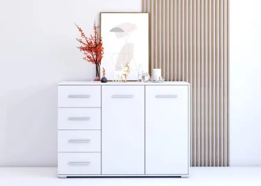 minimalistinio dizaino komoda baltos spalvos su sidabro spalvos rankenėlėmis.