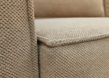 Minimalistinio dizaino rudos spalvos sofa-lova su plačia miegamąja dalimi ir dėže patalynei.