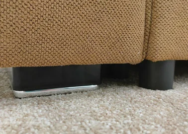 Minimalistinio dizaino rudos spalvos sofa-lova su plačia miegamąja dalimi ir dėže patalynei.