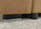 Minimalistinio dizaino rudos spalvos sofa-lova su plačia miegamąja dalimi ir dėže patalynei.