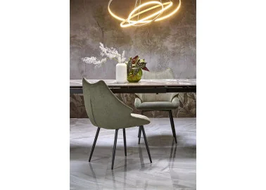 Alyvuogių spalvos elegantiška išskirtinės formos valgomojo kėdė K543. Kėdė apsiūta aukštos kokybės gobelenu, o kojelės pagamintos iš milteliniu būdu dažyto plieno.